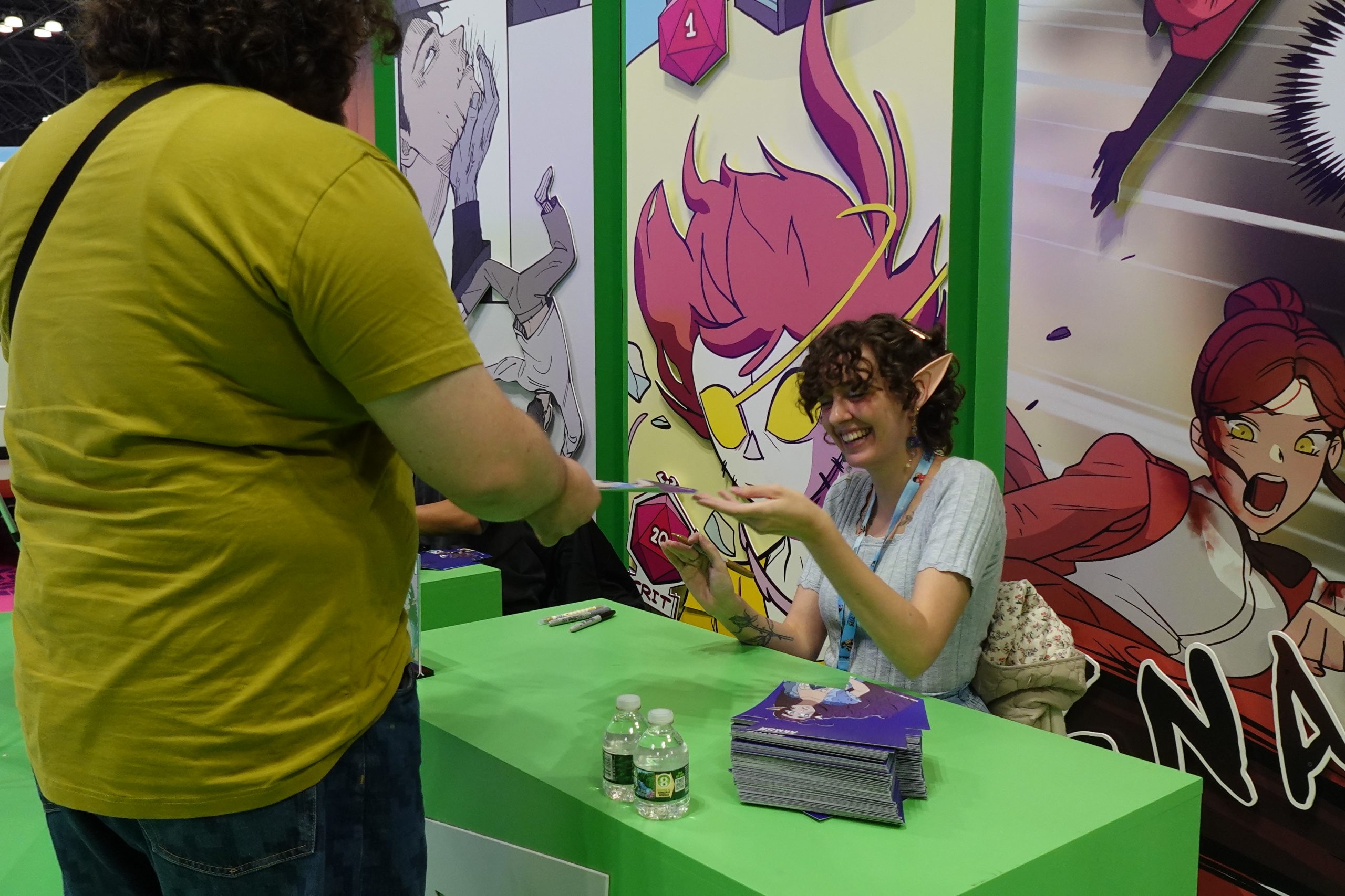 Purpah finishing an autograph and handing it to an excited fan during New York Comic Con 2024.