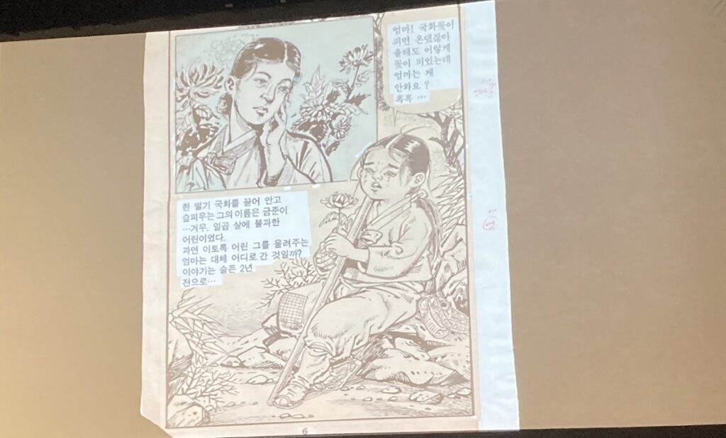 A page from 30,000 Ri in Search of Mother, depicting a small child sitting in the grass and holding a stick. Flowers are blooming around them, while an older woman can be seen in the upper left corner.