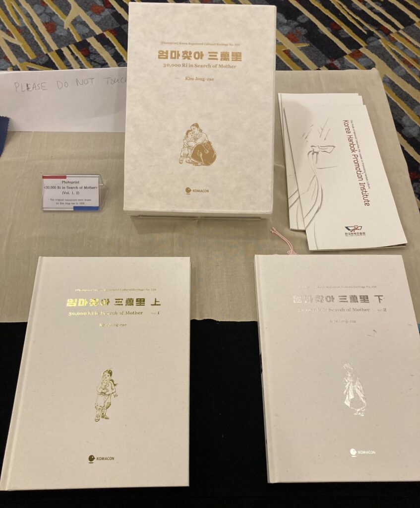 A photograph of hardbound copies of 30,000 Ri in Search of Mother sitting on a table.