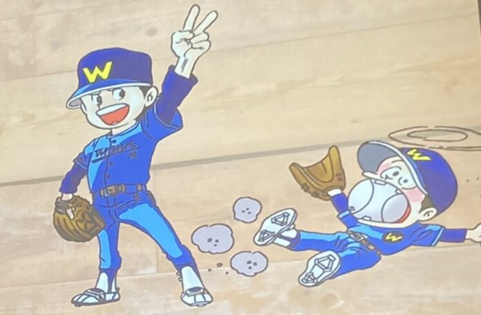 Dokkotak wears a blue baseball cap with a yellow W, and is throwing a peace sign. He can also be seen lying on the ground with a giant baseball stuffed in his mouth.